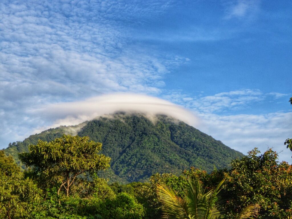 Green mountain landscape beneath a blue sky